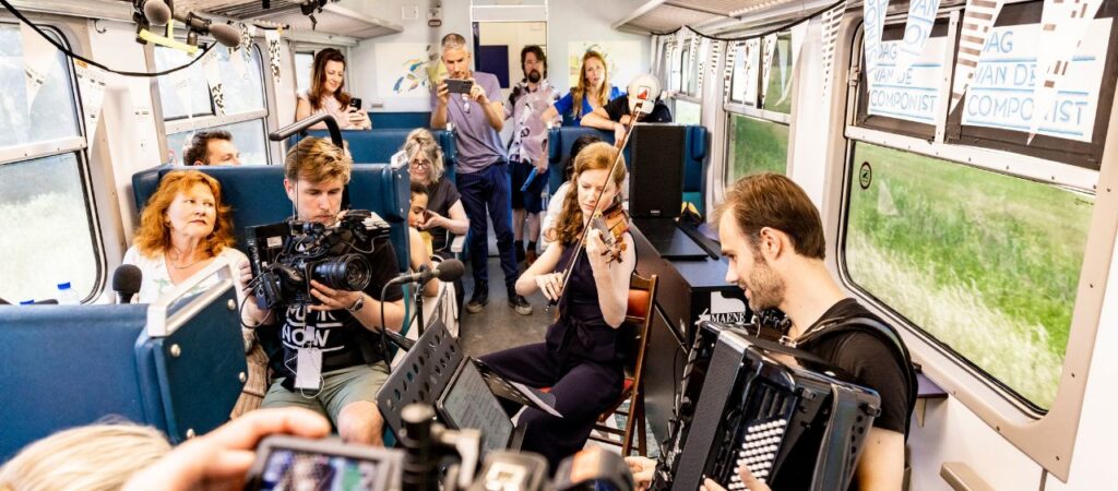 Muzikanten tijdens de Dag van de Componist in een treincoupe.